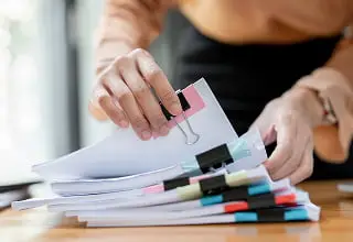 カラフルな付箋とタブで整理された書類ファイル。ピンク、青、黄色などの色分けされたインデックスで書類を分類管理している